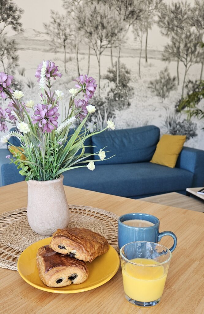 Deux chocolatines, un café et un jus d'orange posés sur une table