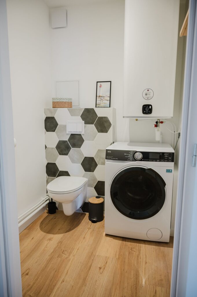 Buanderie avec toilettes, lavabo et lave-linges séchant