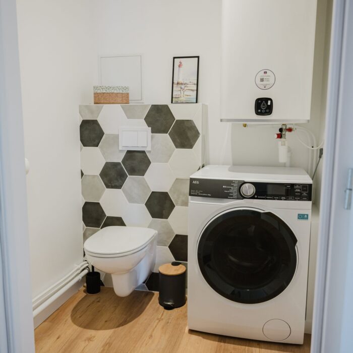 Buanderie avec toilettes, lavabo et lave-linges séchant